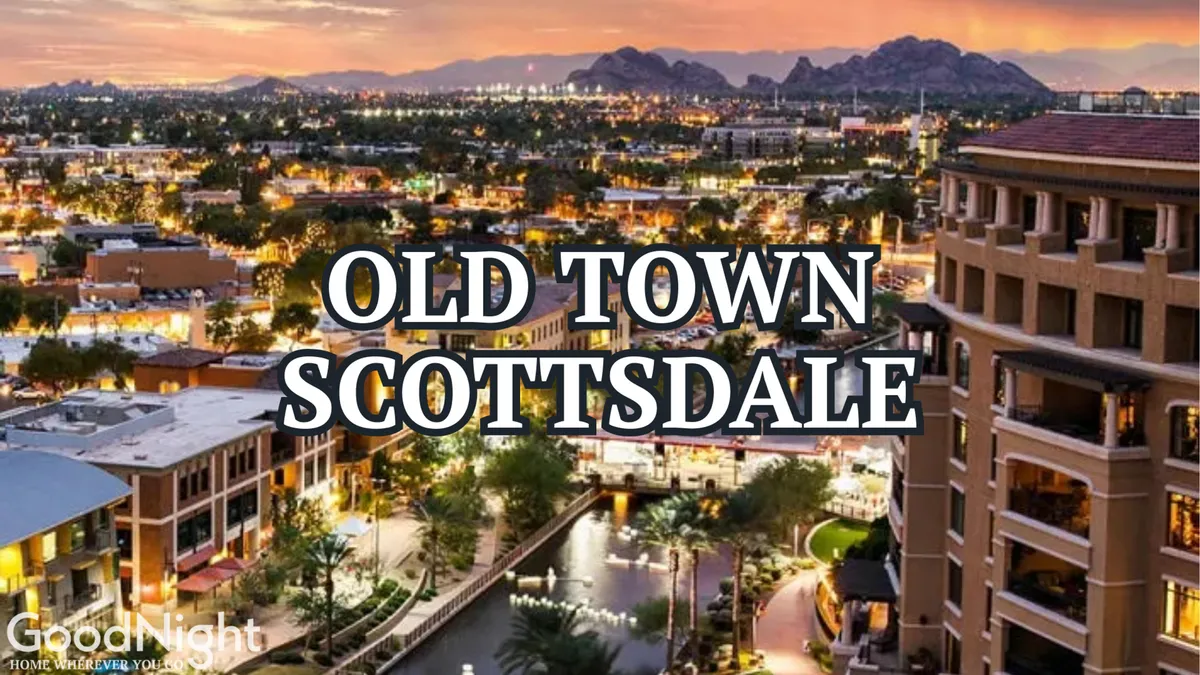 A lively city view featuring the Scottsdale or Phoenix skyline, a scenic waterway lined with palm trees, and a mountain backdrop. The urban environment is inviting and active, suggesting a bustling city atmosphere with spots for dining, shopping, and nightlife.